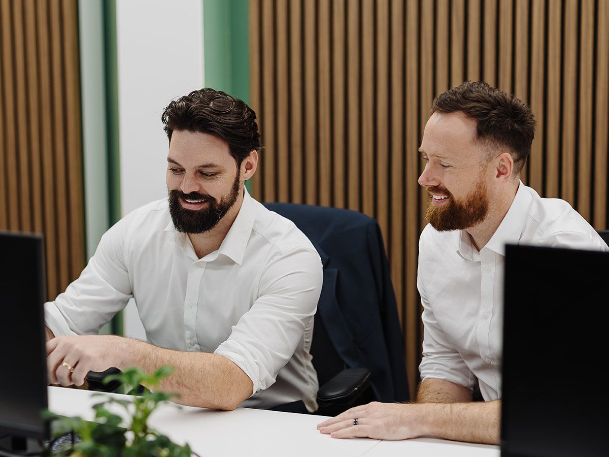 Todd and Daniel, working together at desk.